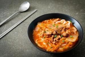 Koreaanse udon ramen-noedels met varkensvlees in kimchi-soep foto