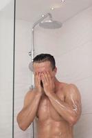 Mens nemen douche in bad foto