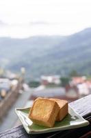 heerlijk ananasgebak in een bord voor afternoontea op houten balustrade van een theehuis in taiwan met een prachtig landschap op de achtergrond, close-up. foto