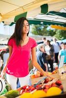 gezonde jonge vrouw winkelen boeren markt verse biologische groenten fruit groenten foto