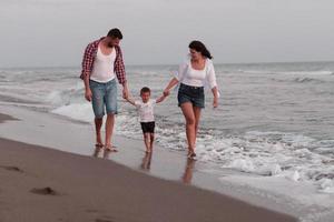 de familie geniet hun vakantie net zo ze wandelen de zanderig strand met hun zoon. selectief focus foto