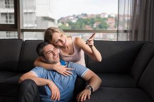 jong knap paar knuffelen Aan de sofa foto