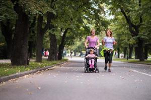 Dames met baby wandelwagen jogging samen foto