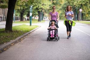 Dames met baby wandelwagen jogging samen foto