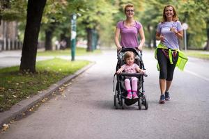 Dames met baby wandelwagen jogging samen foto