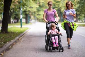 Dames met baby wandelwagen jogging samen foto