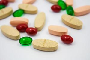 gekleurde pillen, tabletten en capsules op een witte achtergrond foto
