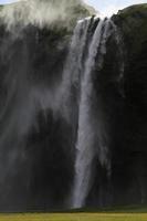 wind slagen omhoog een waterval in IJsland foto