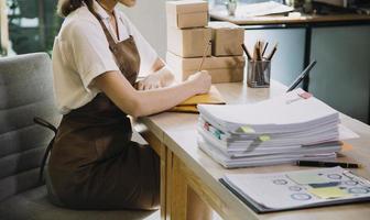 portret van beginnend klein ondernemingen mkb eigenaren, twee Aziatisch vrouw controleren online bestellingen verkoop producten werken met dozen freelance werk Bij huis kantoor, mkb bedrijf online klein medium onderneming foto