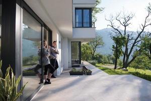 paar genieten van Aan de deur van hun luxe huis villa foto