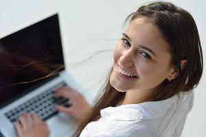 ontspannen jong vrouw Bij huis werken Aan laptop computer foto