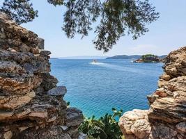 uitzicht door ruïnes van stenen naar het oude gedeelte van de stad skiathos op het eiland skiathos, griekenland. foto