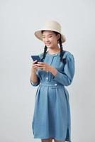 mooi hoor charmant aantrekkelijk school- meisje Holding in handen mobiele telefoon maken smm post geïsoleerd over- wit achtergrond foto