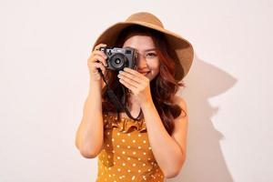 vrouw reiziger met een camera, beige achtergrond foto