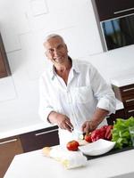 Mens Koken Bij huis voorbereidingen treffen salade in keuken foto