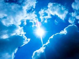 blauwe lucht met witte wolken en zon foto