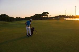 golfspeler wandelen en draag- golf zak Bij mooi zonsondergang foto