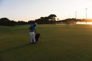 golfspeler wandelen en draag- golf zak Bij mooi zonsondergang foto