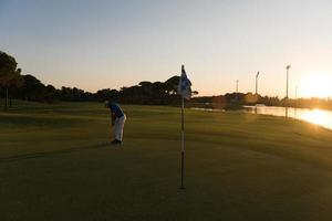 golfspeler raken bal naar gat foto