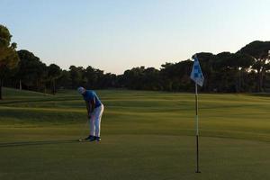 golfspeler raken bal naar gat foto