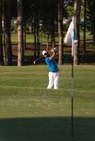 pro golfspeler raken een zand bunker schot foto