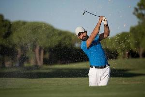 pro golfspeler raken een zand bunker schot foto