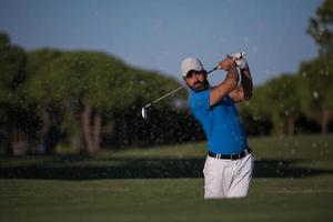 pro golfspeler raken een zand bunker schot foto