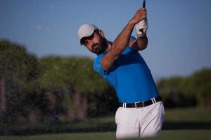 pro golfspeler raken een zand bunker schot foto