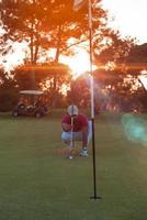 golf speler het richten perfect schot Aan mooi zonsondergang foto