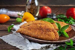 traditioneel Krim Tataars keuken, chebureki met kip vlees. gebakken empanadas Aan houten achtergrond foto