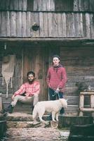 frineds samen in voorkant van oud houten huis foto