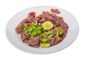 rundvlees carpaccio Aan de bord en wit achtergrond foto