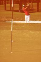 golfspeler raken een zand bunker schot foto