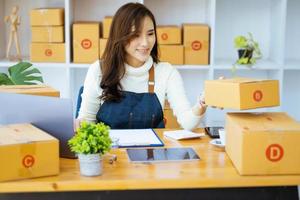 werk van huis. gelukkig Dames verkoop producten online opstarten klein bedrijf eigenaren zijn plukken omhoog pakket dozen naar pak klant bestellingen en bereiden hen voor port. foto