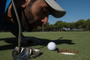 golf speler blazen bal in gat foto