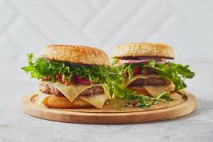 twee hamburgers met kalfsvlees kotelet en kruiden Aan houten snijdend bord
