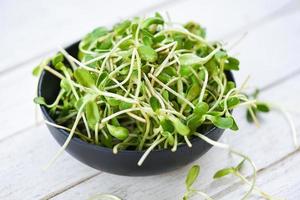 groen jong zonnebloem spruiten Aan kom voor gekookt voedsel gezond groenten - zonnebloem zaailing concept foto