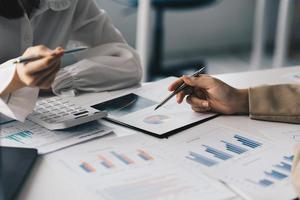 Aziatisch bedrijf vrouw of accountant Doen wiskunde en analyseren met rekenmachine en papierwerk Aan bureau, account, raadplegen, audit en besparing concept. foto