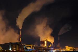 nacht industrieel landschap milieu verontreiniging verspilling van thermisch macht fabriek. groot pijpen van chemisch industrie onderneming fabriek foto