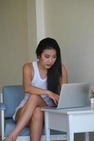 nieuw normaal, een zakenvrouw gebruik makend van computer naar werk voor een bedrijf via de internet Aan uw bureau Bij huis. foto