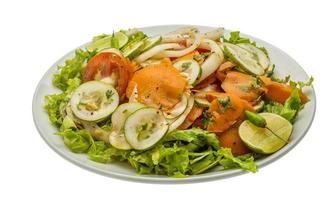 komkommer salade Aan de bord en wit achtergrond foto