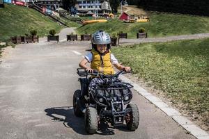 glimlachen jongen aan het leren naar rit vierwieler Aan een spoor. foto