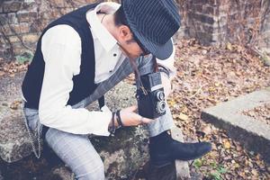 fotograaf op zoek door vizier en nemen foto met medium formaat camera.