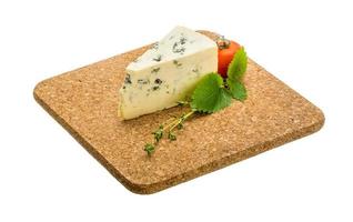blauwe kaas op houten plaat en witte achtergrond foto