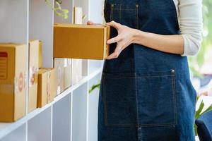 werk van huis. gelukkig Dames verkoop producten online opstarten klein bedrijf eigenaren zijn plukken omhoog pakket dozen naar pak klant bestellingen en bereiden hen voor port. foto