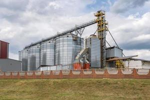 moderne graanschuurlift en zaadreinigingslijn. zilversilo's op agroverwerkings- en productiefabriek voor het verwerken van drogen, reinigen en opslaan van landbouwproducten, meel, granen en graan. foto