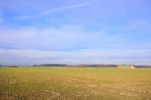 breed landschap in Beieren in herfst met geoogst velden, een klein dorp en een blauw lucht met wolken foto