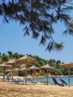 ongerept uitzicht op de baai van een Grieks eiland met lege ligstoelen en parasols.. foto