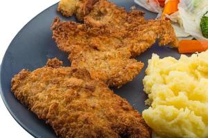 schnitzel Aan de bord en wit achtergrond foto