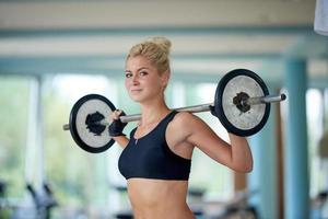 jong vrouw in geschiktheid Sportschool hijs- gewichten foto